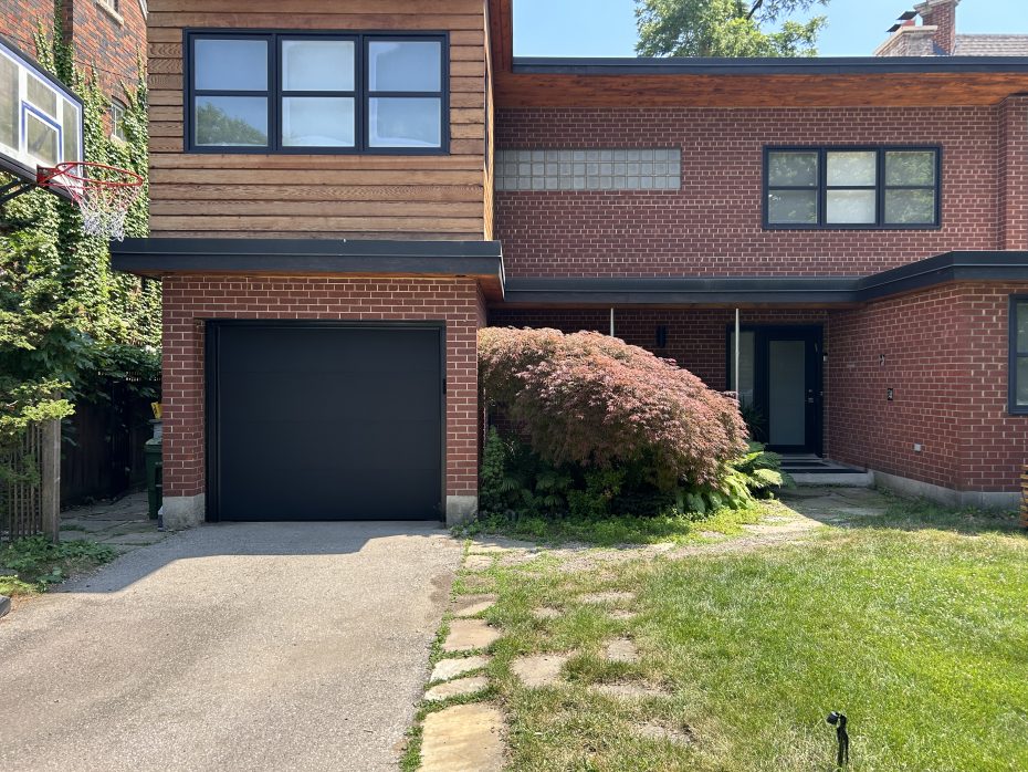 Sleek black flush garage door replacement highlighting the clean lines and matching aluminum capping.