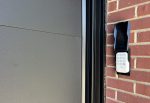 Close-up of a newly installed garage door keypad alongside a premium black insulated steel garage door panel.