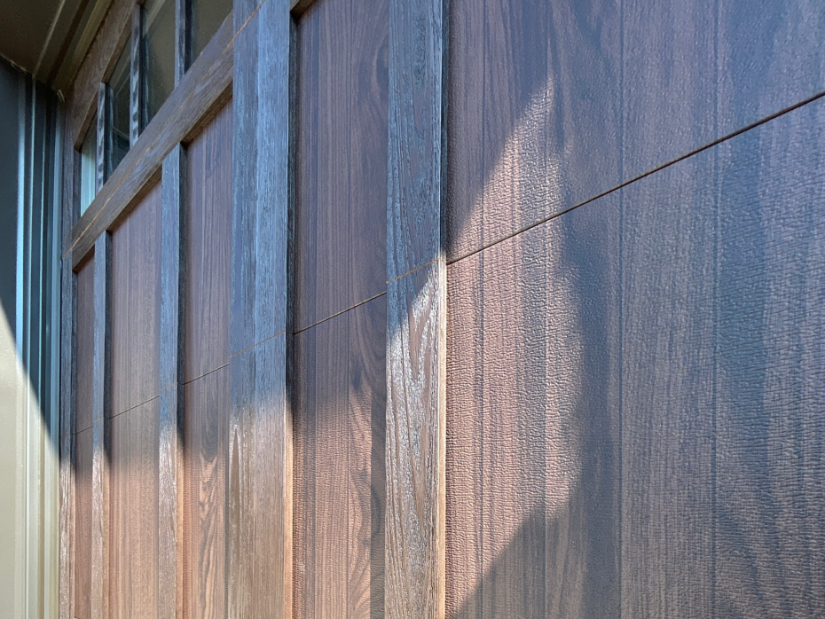 Close-up texture detail of dark faux wood-grain finish on a carriage style garage door panel in Woodbridge, Ontario.