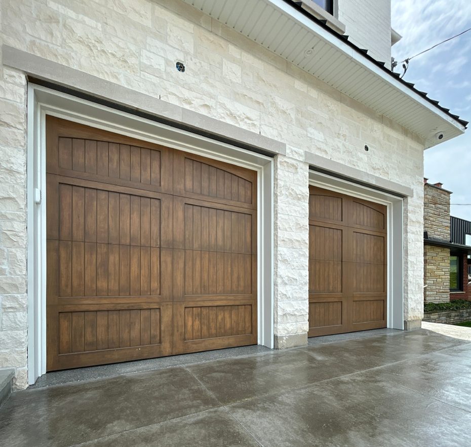 Close-up texture view of a faux wood stain overlay panel on a custom steel garage door.
